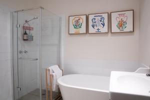 a bathroom with a bath tub and three framed posters at Clara Luce` in Bright +76 photos