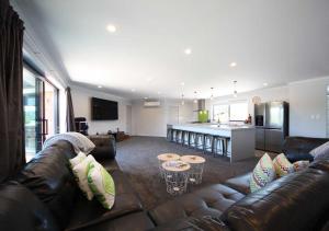 a living room with a couch and a kitchen at Mata-au Lodge in Beaumont