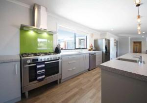 a large kitchen with a stove and a sink at Mata-au Lodge in Beaumont +11 photos