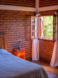 a bedroom with a brick wall and a bed and a window at Buen día María Cabañas Chapadmalal in Colonia Chapadmalal +22 photos