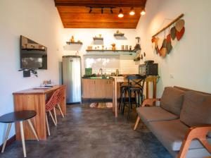 a living room with a couch and a kitchen at Chalé Lar do Capão in Vale do Capao