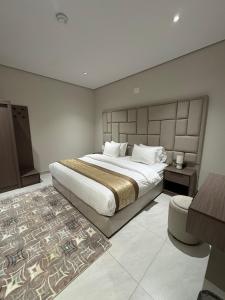 a bedroom with a large bed and a table at شقق طلال الفندقية- Talal hotel apartments in Al-ʿUla +22 photos
