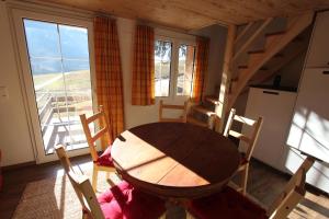 a dining room with a table and chairs and a kitchen at Chalet Daheim in Reckingen - Gluringen