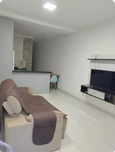 a living room with a couch and a flat screen tv at Espaço amplo e privativo in Trindade