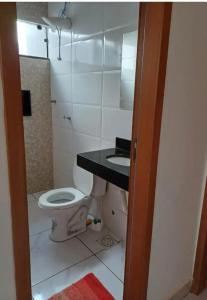 a bathroom with a toilet and a sink at Espaço amplo e privativo in Trindade