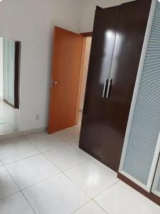 a large brown door in a room with a tile floor at Espaço amplo e privativo in Trindade
