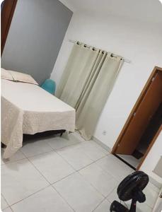 a bedroom with a bed and a shower curtain at Espaço amplo e privativo in Trindade