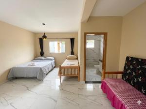 a bedroom with two beds and a bathroom with a shower at Casa Espaçosa com Piscina, 4 Quartos e Ar-Condicionado in Itanhaém +6 photos