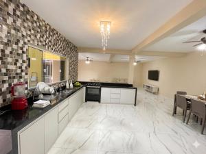 a large kitchen with a counter and a dining room at Casa Espaçosa com Piscina, 4 Quartos e Ar-Condicionado in Itanhaém
