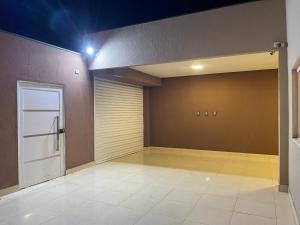 an empty garage with a door and a tile floor at Lilly Queen I in Londrina