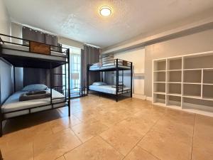 two bunk beds in a room with a tile floor at Bek's Hostel in Hallandale Beach