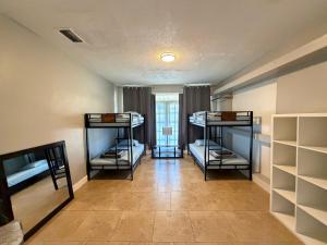a room with three bunk beds in it with a hallway at Bek's Hostel in Hallandale Beach