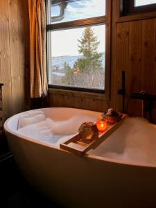 a bath tub with a candle and a window at Original Trybo Cabin At Trysil Mountain in Trysil
