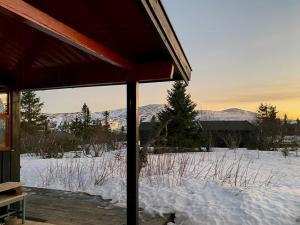 a snow covered yard with mountains in the background at Original Trybo Cabin At Trysil Mountain in Trysil
