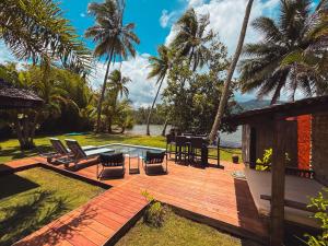 a deck with chairs and a table and a pool at Villa Mitirapa in Tohautu