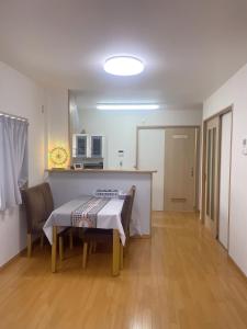 a dining room with a table and a kitchen at 桃谷民宿 in Osaka