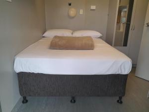 a large bed with a brown pillow on top of it at Cheap Rooms North Brisbane in Narangba