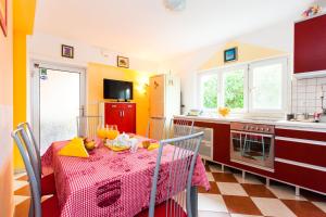 cocina con mesa y mantel rojo en Holiday Home Villa Pindo, en Ston