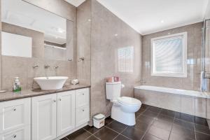 a bathroom with a toilet and a sink and a tub at The Dunes 1 - BYO Linen in Apollo Bay