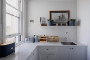 a white kitchen with a sink and a window at Shipwrights Arms Hotel in Hobart +40 photos