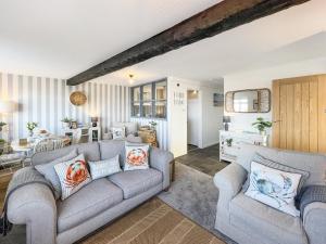 a living room with two couches and a table at Beach View Cottage Minehead in Minehead