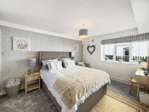 a bedroom with a large bed and a window at Beach View Cottage Minehead in Minehead