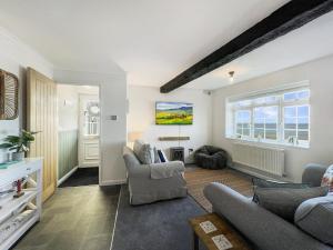 a living room with a couch and chairs at Beach View Cottage Minehead in Minehead