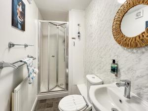 a bathroom with a shower and a toilet and a sink at Beach View Cottage Minehead in Minehead +16 photos