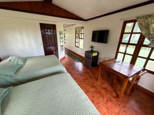 a bedroom with a bed and a table and a television at Brisa Del Mar in Playa Hermosa