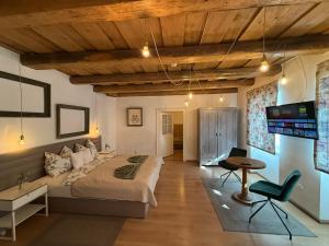 a bedroom with a bed and a flat screen tv at Corte Apartman in Pápa