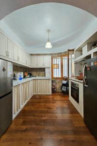 Eine Küche mit weißen Schränken und Holzboden in der Unterkunft Wanderlust Hostel B & B in Santiago