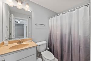 a bathroom with a toilet and a sink and a shower at Ocean Dream in Kill Devil Hills +41 photos