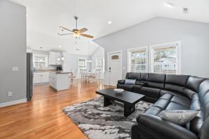 a living room with a black leather couch and a table at Ocean Dream in Kill Devil Hills