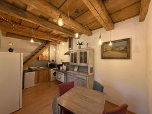 a kitchen with a table and a refrigerator in a room at Corte Apartman in Pápa
