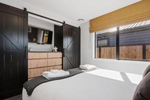a bedroom with a large bed with two towels at The Reserve on Wooing Tree in Cromwell