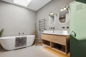 a bathroom with two sinks and a tub and mirrors at The Reserve on Wooing Tree in Cromwell