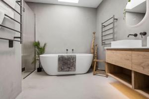 a bathroom with a large white tub and a sink at The Reserve on Wooing Tree in Cromwell