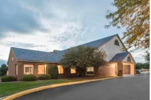 a large house with a driveway in front of it at Dodgeville inn & suites in Dodgeville
