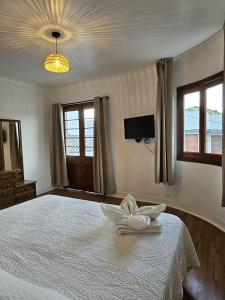 ein Schlafzimmer mit einem weißen Bett, auf dem ein Handtuch liegt in der Unterkunft Wanderlust Hostel B & B in Santiago
