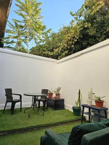 eine Terrasse mit Tisch, Stühlen und Pflanzen in der Unterkunft Wanderlust Hostel B & B in Santiago