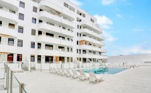 a hotel with a swimming pool and lounge chairs at Sobre el Mar en Edificio Magallanes in El Médano