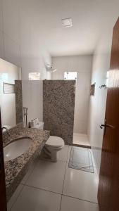 a bathroom with a toilet and a sink and a shower at Hotel Estrela de Minas in São Gabriel +49 photos