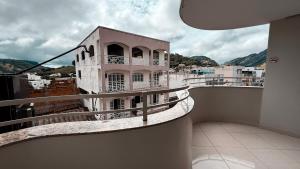 a balcony with a pink building on top of a building at Hotel Estrela de Minas in São Gabriel