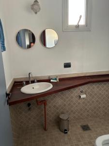 a bathroom with a sink and two mirrors at NM Apartamentos - LANUS OESTE in Villa Sarmiento