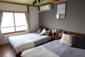 a bedroom with two beds and a window at Biei Relax Stay B in Biei