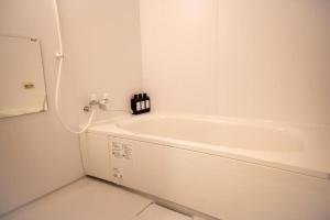 a white bath tub in a white bathroom at Biei Relax Stay B in Biei +23 photos