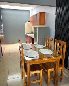 a dining room table with four chairs and a kitchen at Oasis House 1 in Cabuya +9 photos