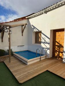 a hot tub on a wooden deck next to a house at La Casa de Célia in Valencia de Don Juan
