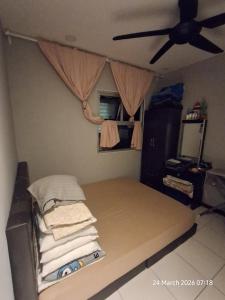 a bed in a room with a ceiling fan at D Kristal Apartment in Semenyih