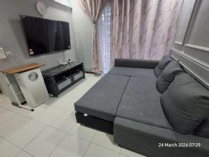 a living room with a couch and a flat screen tv at D Kristal Apartment in Semenyih